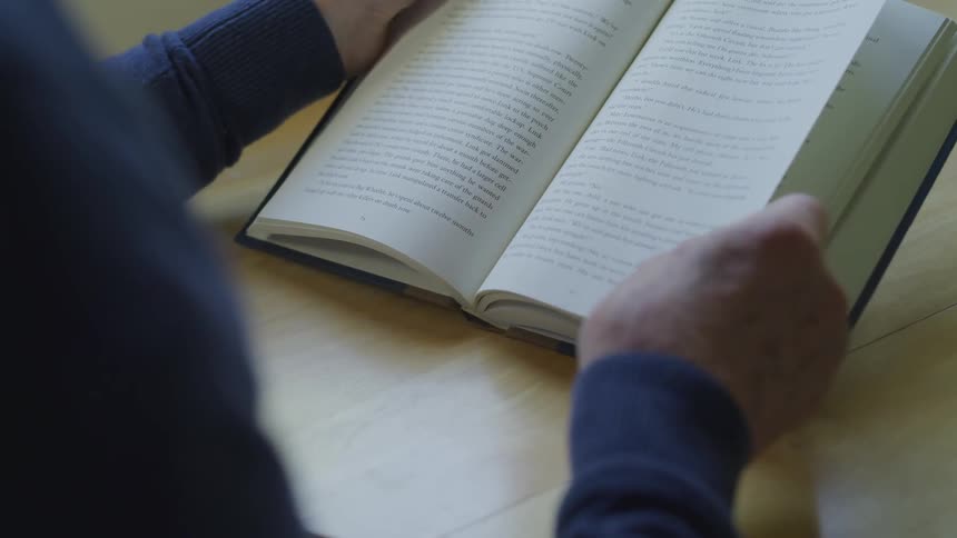 A person is reading a book on the table