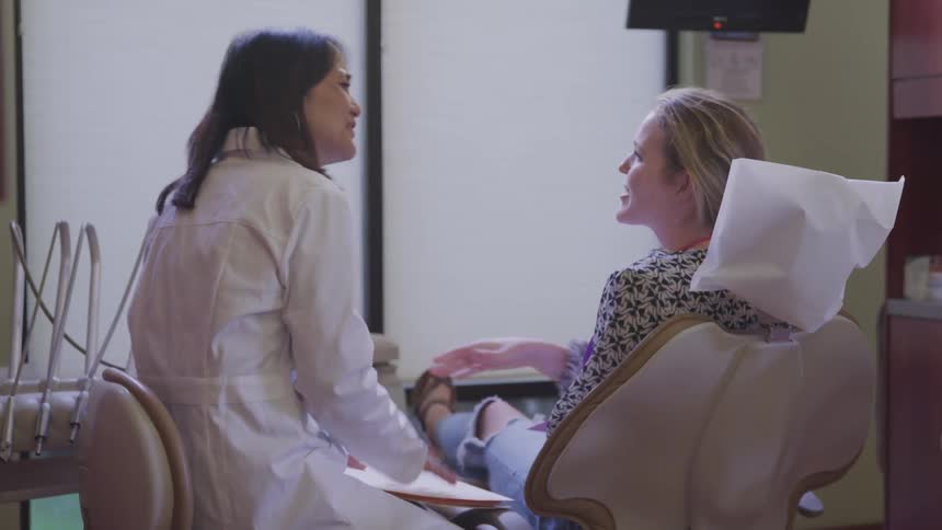 A woman doctor shakes the hand of a woman patient in a clinic