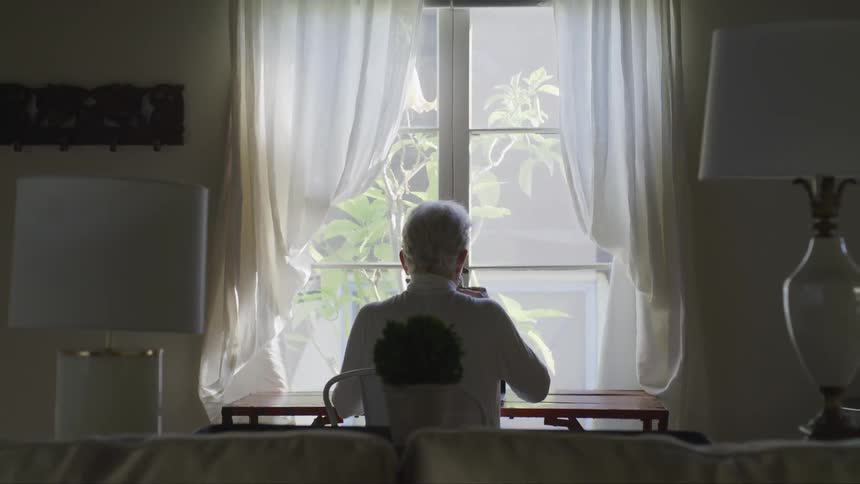 A man is having something to drink at his dining room table