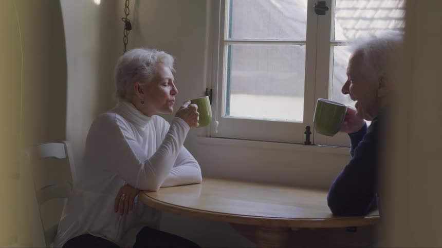 A man and a woman sitting at a table drinking tea