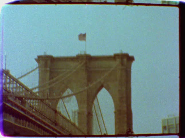 An american flag sits atop a city bridge