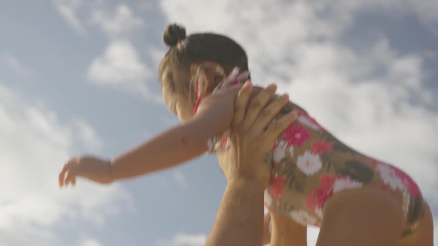 A man tosses his daughter up in the air and catches her