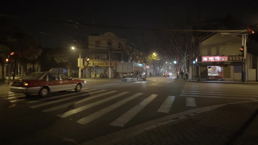 Cars driving down a city street at night