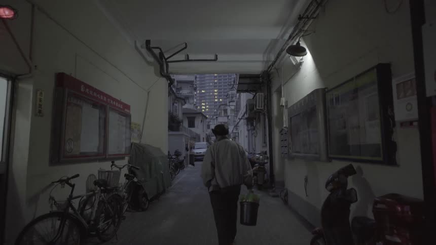 A man is walking through an alleyway of a neighborhood