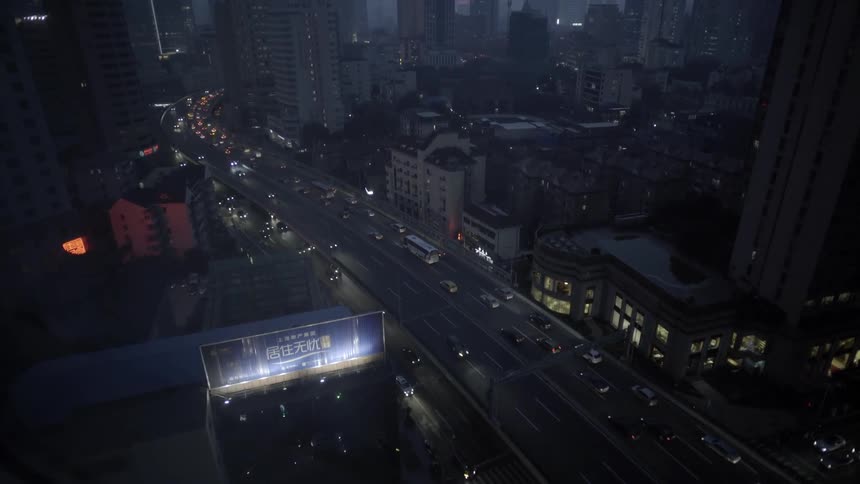 Cars drive on a city street at night