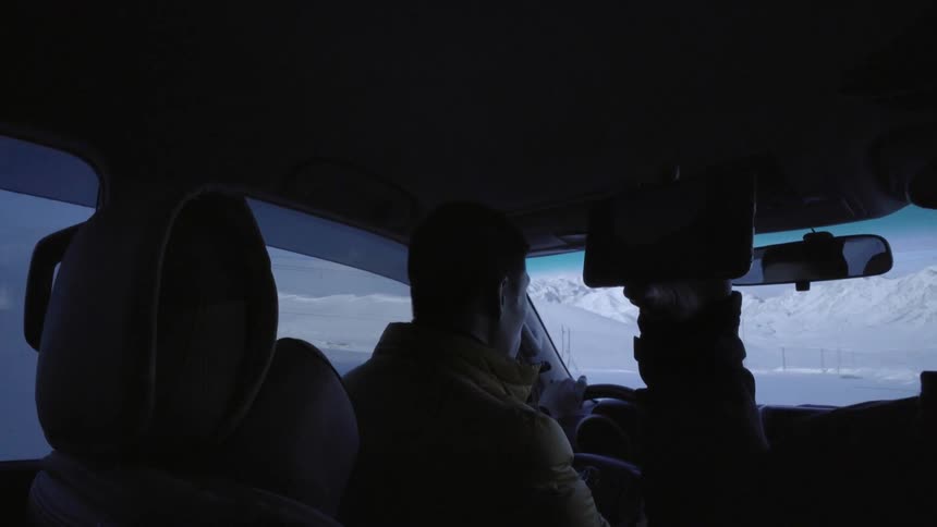 Man driving down road with passenger