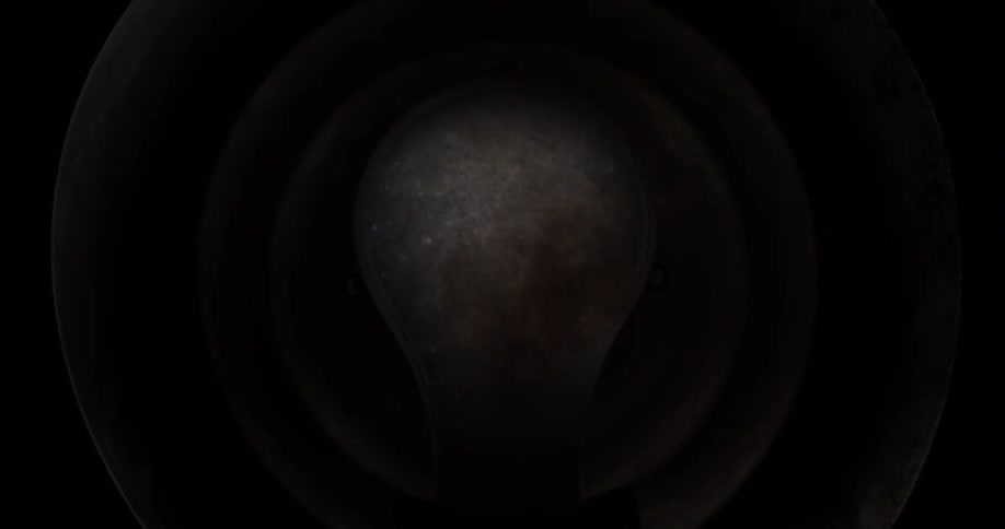A bulb briefly flashes in a dark area