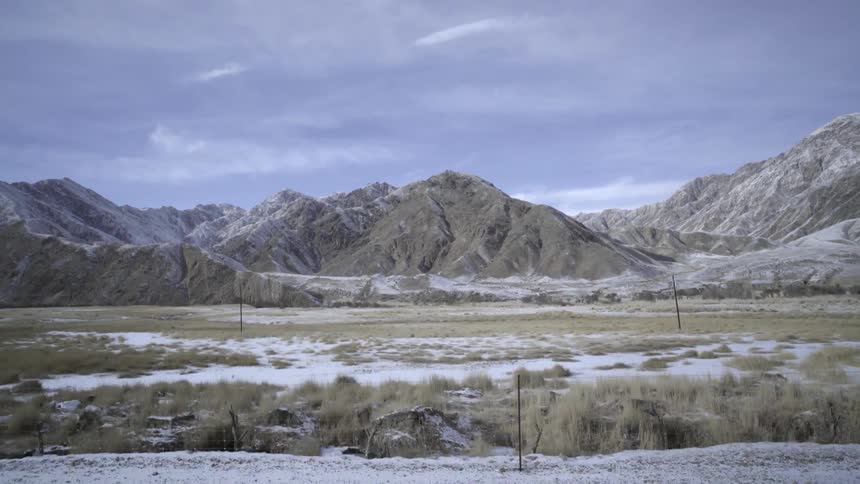 Mountains and the ground in front of them covered in snow on a cloudy day