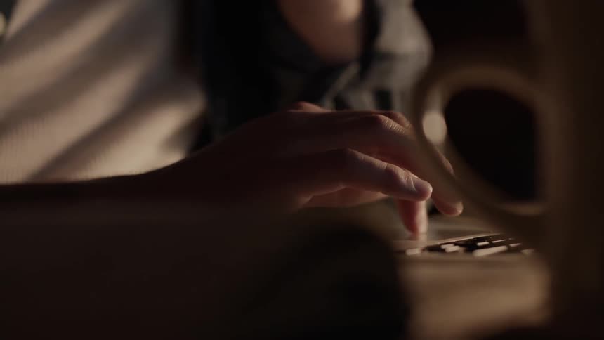 A person is using their laptop in the dark