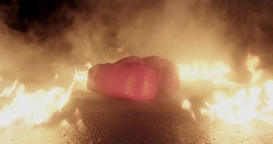 A fire burns around a pair of red boxing gloves