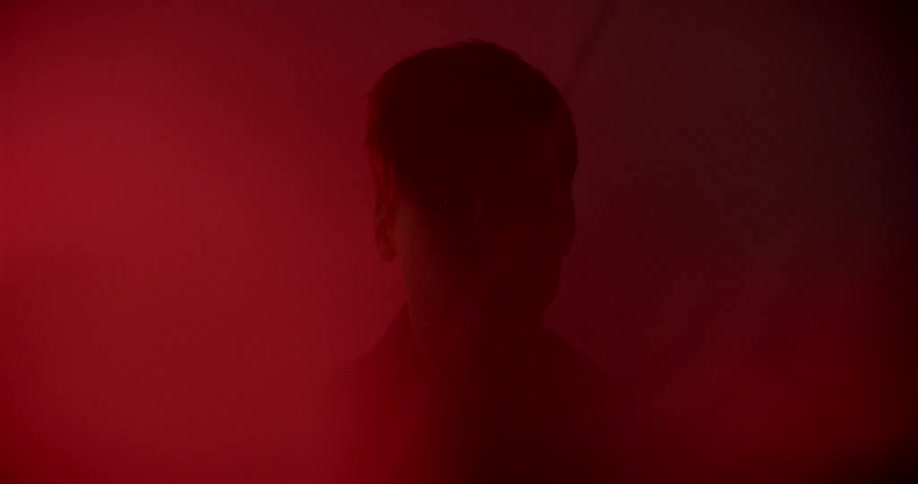 The silhouette of a mans head in a red foggy light