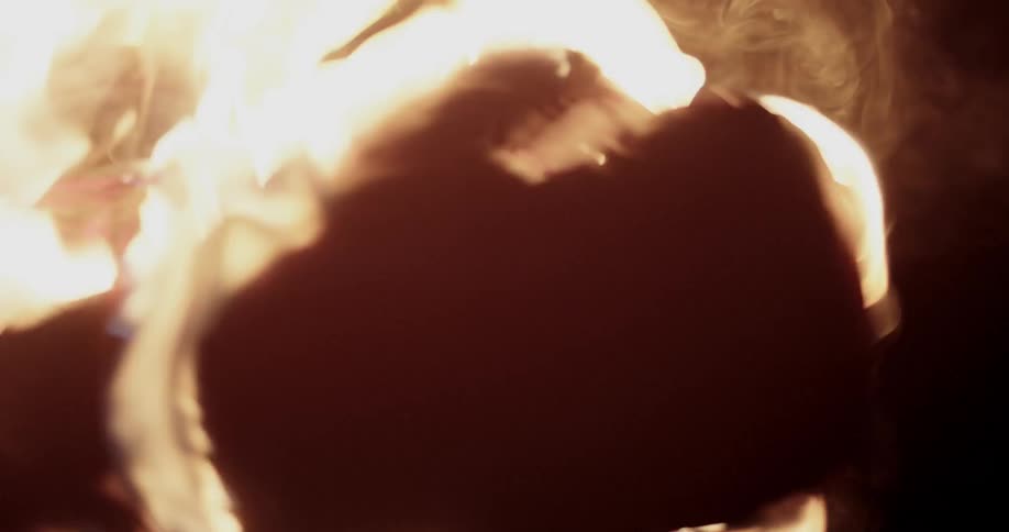 A pair of burning boxing gloves jabbing in the darkness