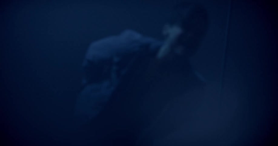 Male singer screams and sings a song in the spotlight in the dark music studio