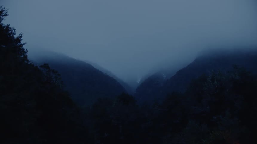 The tall mountains are covered with fog