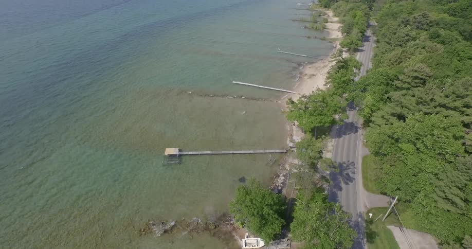 The vehicles drive on the road past piers