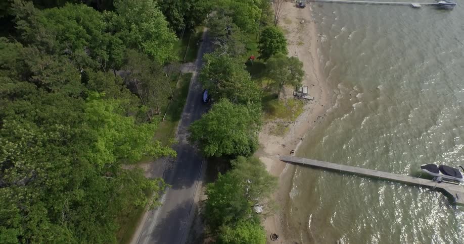 The vehicle transports a boat on the road by the shore