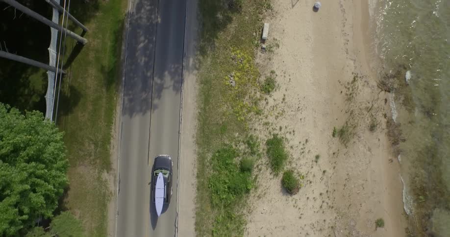 Birds eye view of a vehicle driving with a kayak on the roof
