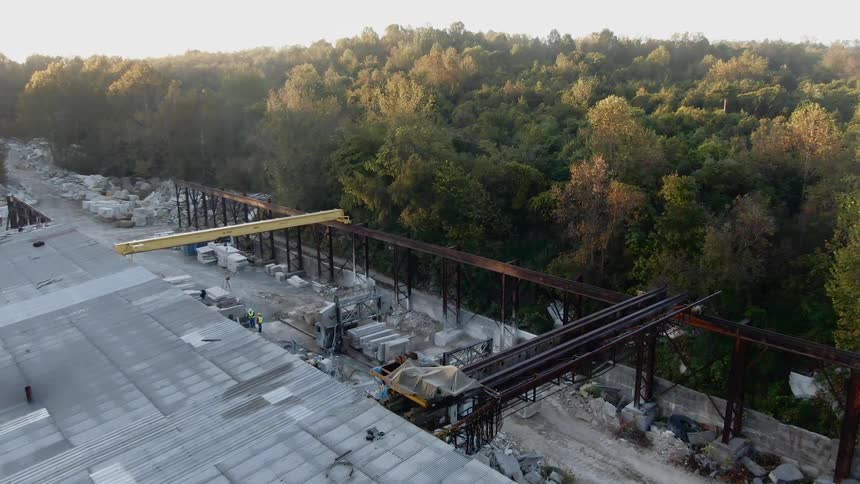 An open air work site sits in the middle of a dense forest