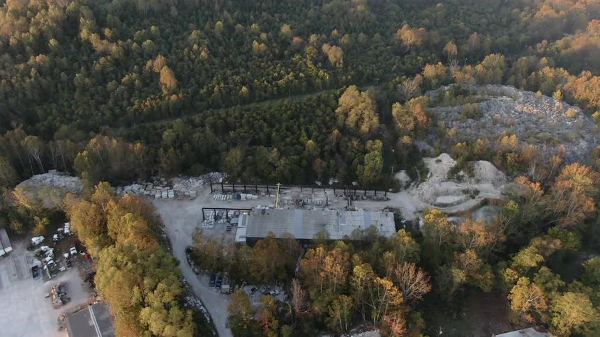 Flying over an industrial area in the middle of the woods