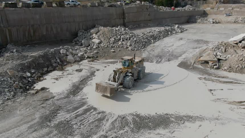 A bulldozer is carrying rocks in the quarry