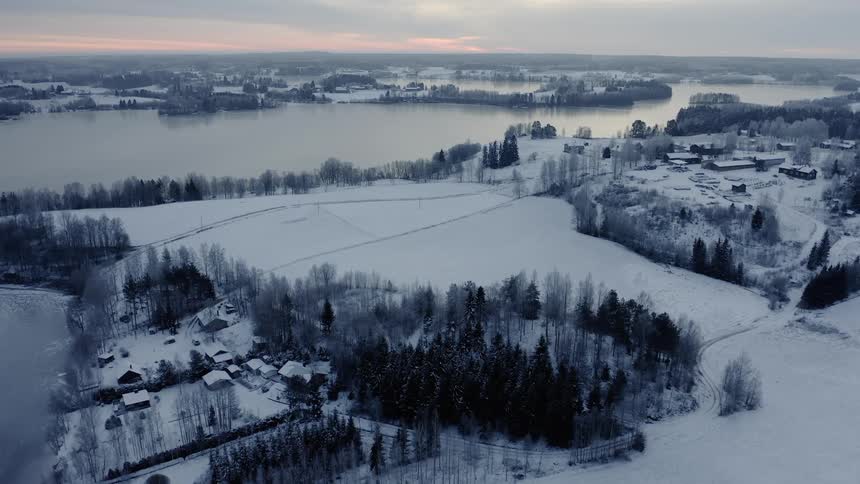 Small villages covered in snow next to a lake
