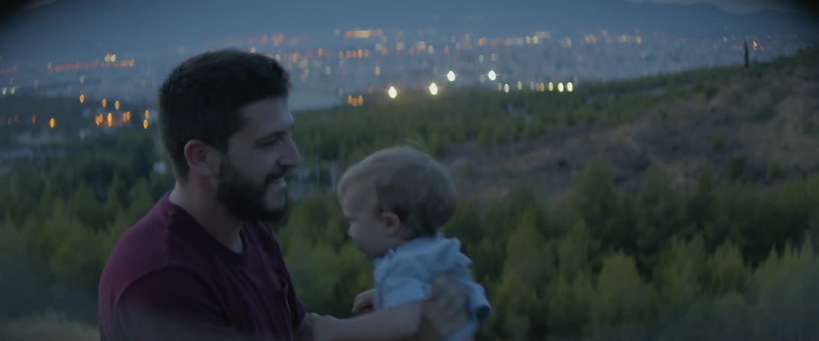 A man laughs and tosses a baby playfully in the air
