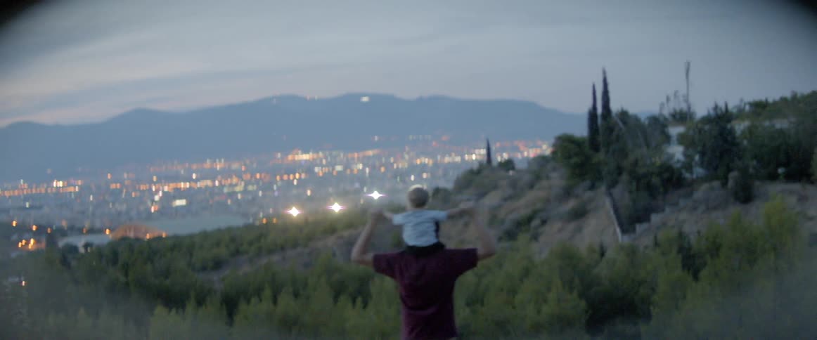 A man carrying a baby on his shoulders on a hike