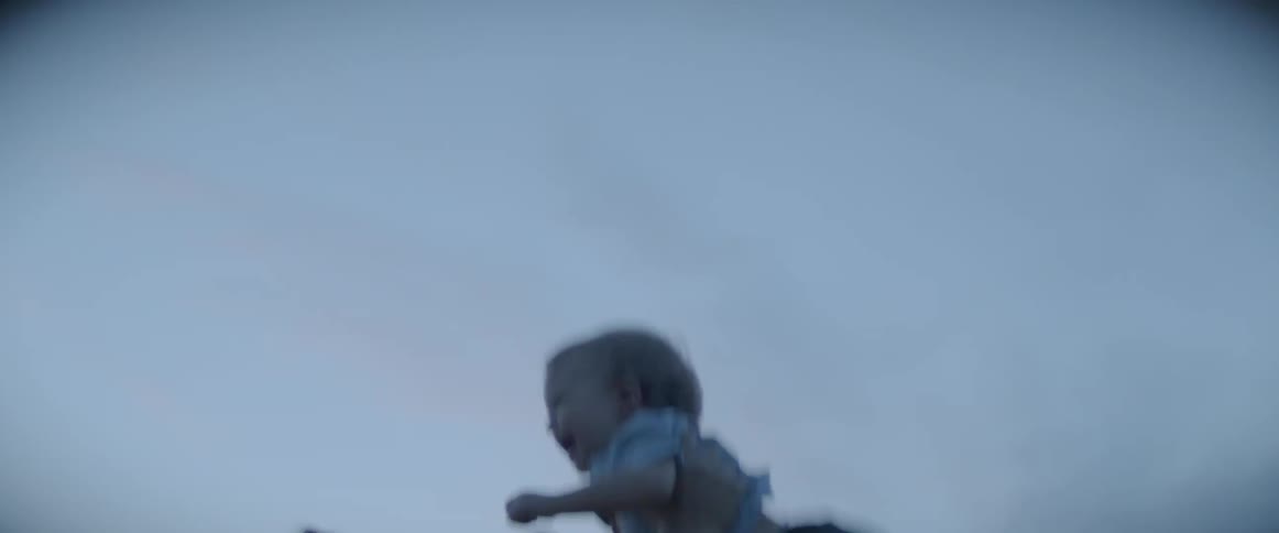 Father tossing baby son playfully in the air at sunset