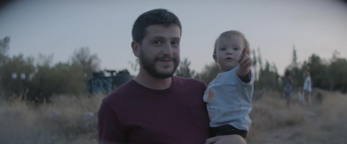 A man carrying a baby in a field