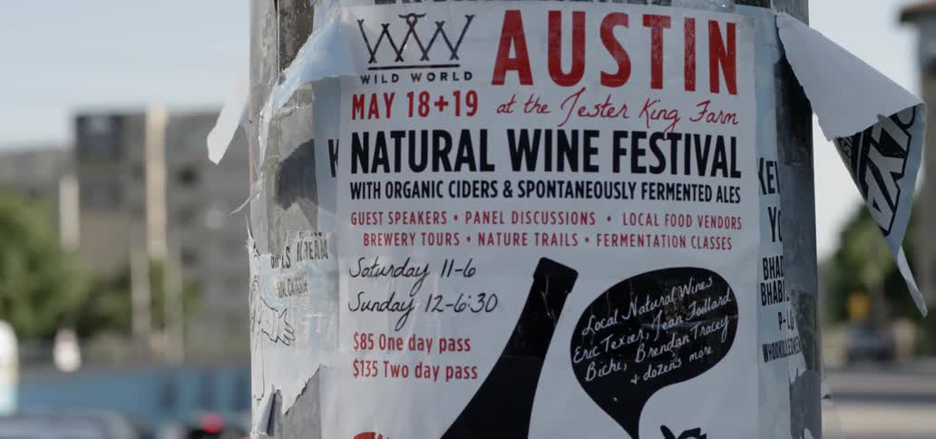 A sign for a festival hands on a post