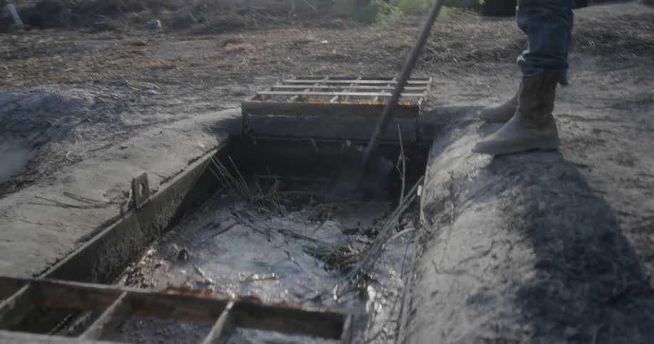 A man cleans debris out of storm drain