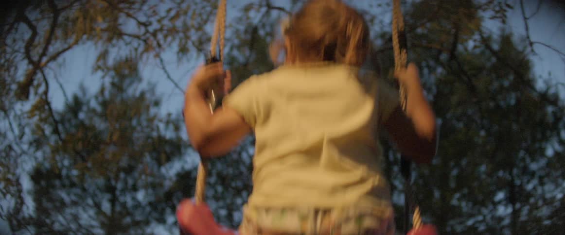 A young girl that is swinging on a swing