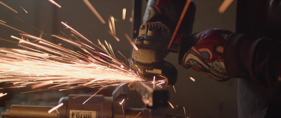 A man grinds metal and sparks fly