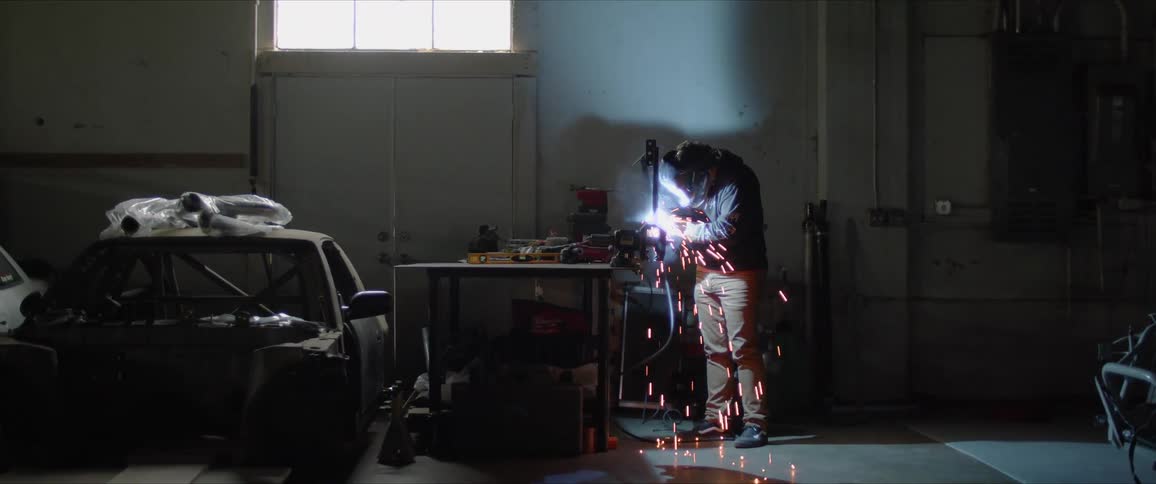 A man welds in a garage