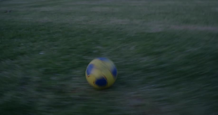 A kid is playing soccer outside