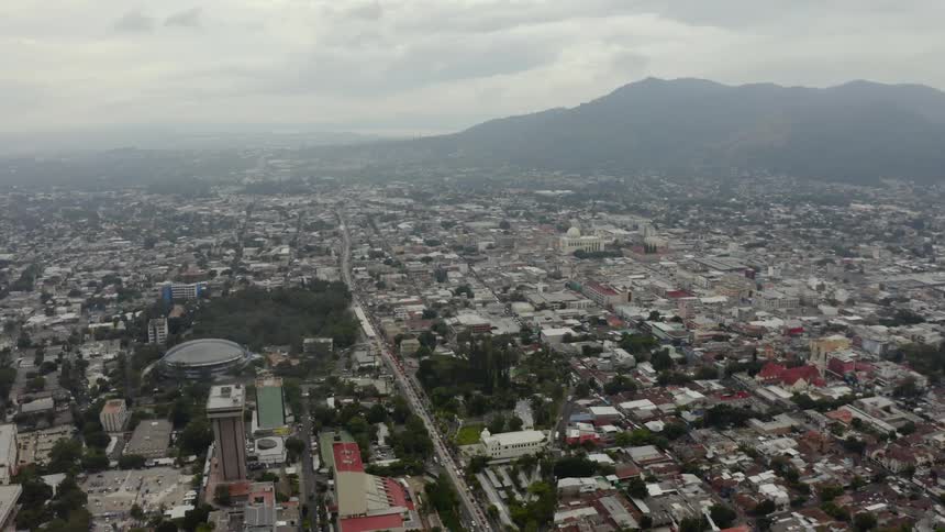 Flying over a city with hills in the distance