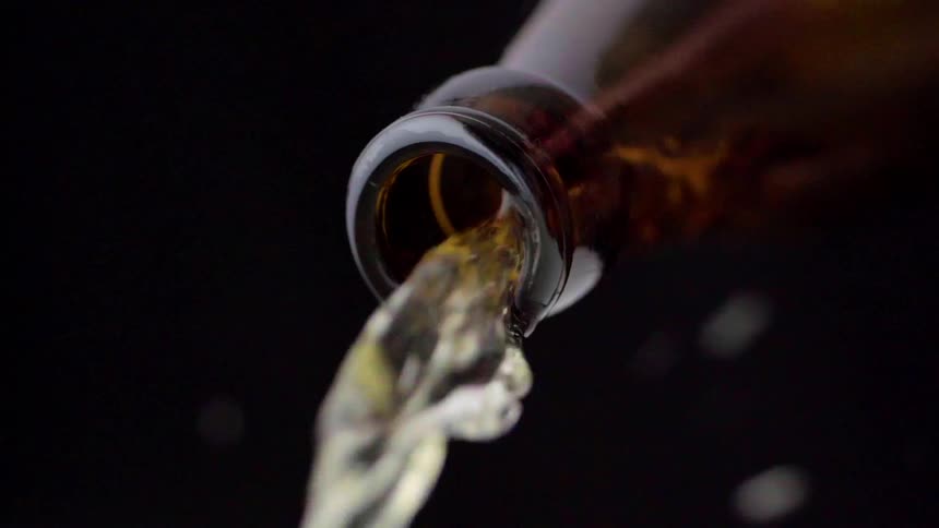 Beer flowing from a brown glass bottle