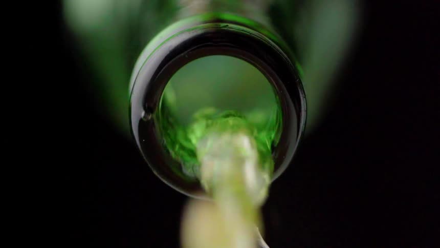 Liquid pours out of a glass bottle
