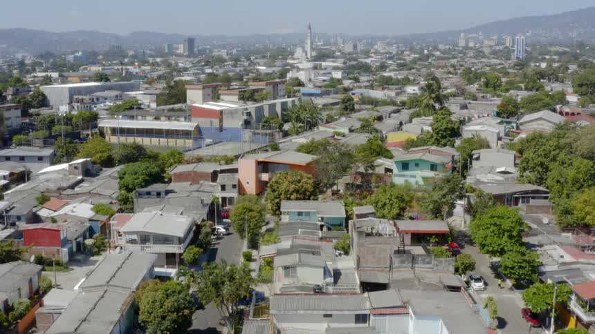 Passing over neighborhood streets and rooftops on a sunny day