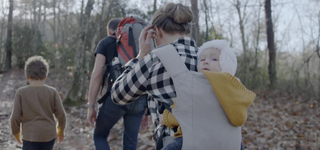 A man woman and two children hike through a forest