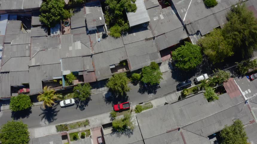 A dense neighborhood with vehicles parked on the street