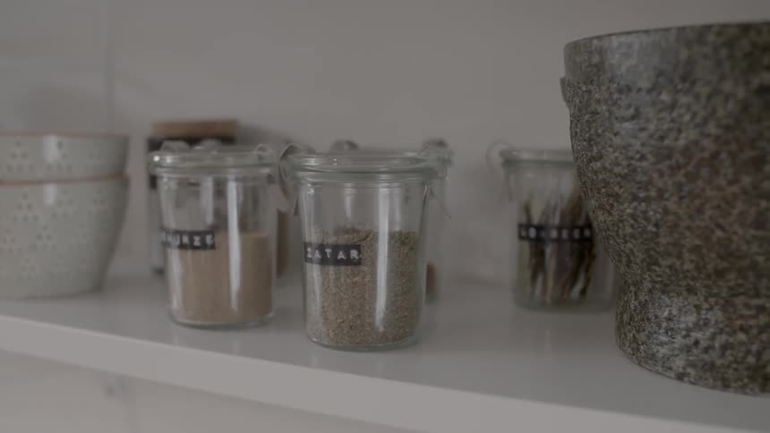 Jars of hers sit on a shelf beside pieces of pottery