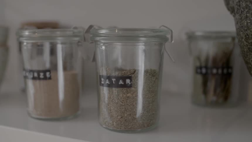 Jars of spices sit on a shelf
