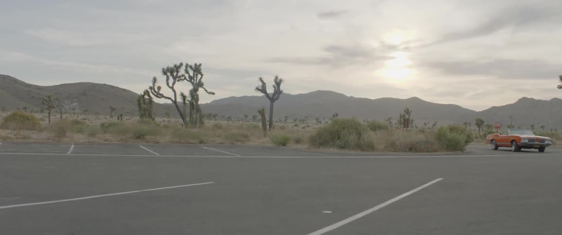 A vehicle is pulling into the parking lot in the desert