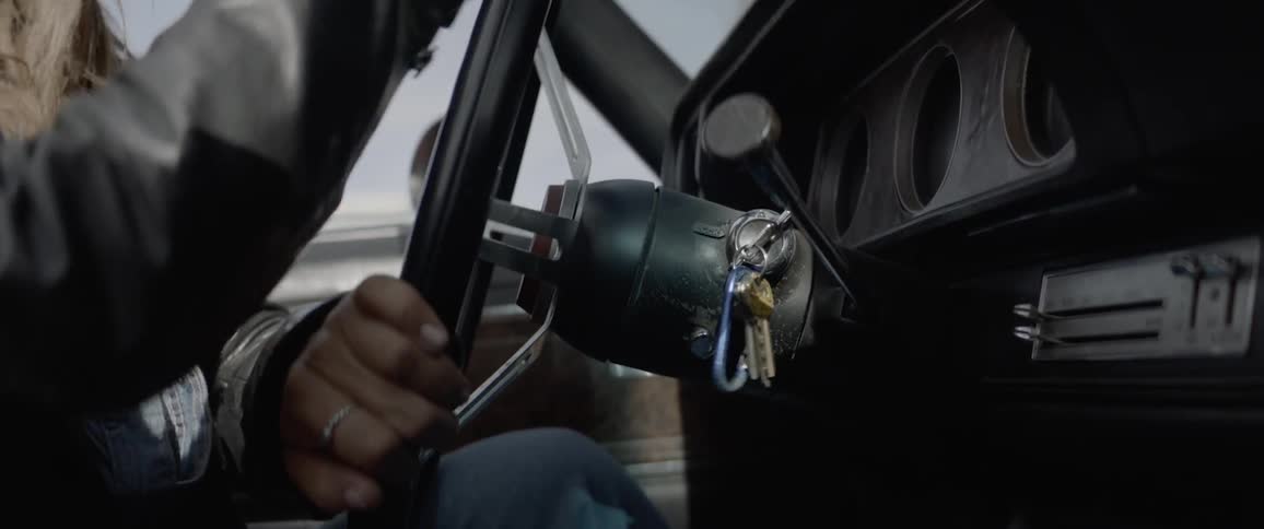 Woman starting up a classic car backing up and driving off