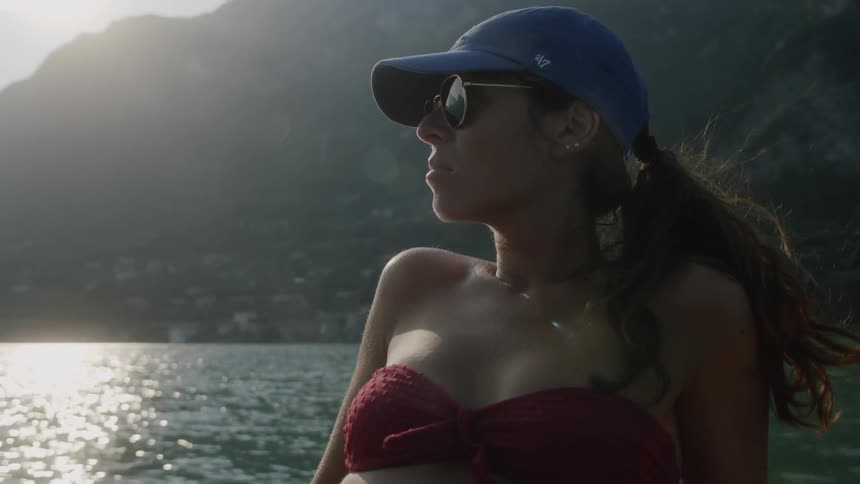 A young woman lies back on a boat and relaxes