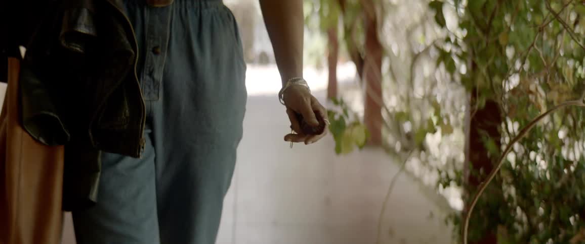 A woman walks on the sidewalk
