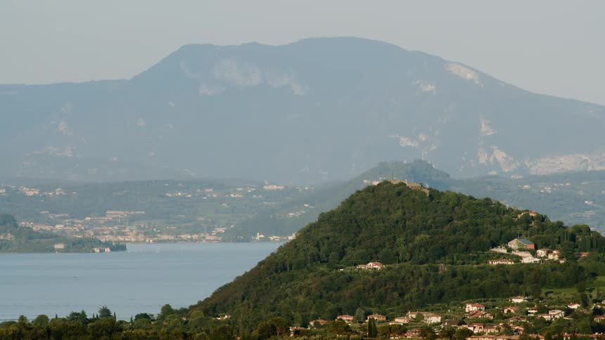 A mountain in covered by trees and housing