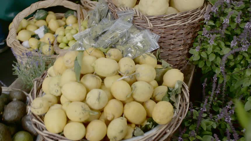 Fresh picked fruit and vegetables in baskets surrounded by herb and flowering plants