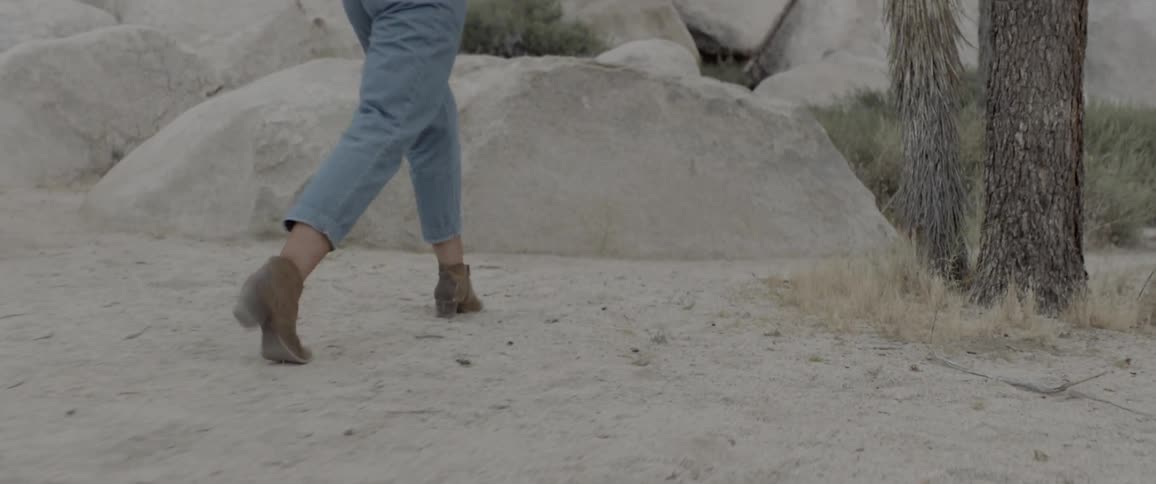 A footage of female with heels run on the desert